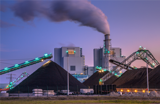 a coal fired power station chimney with smoke billowing from it