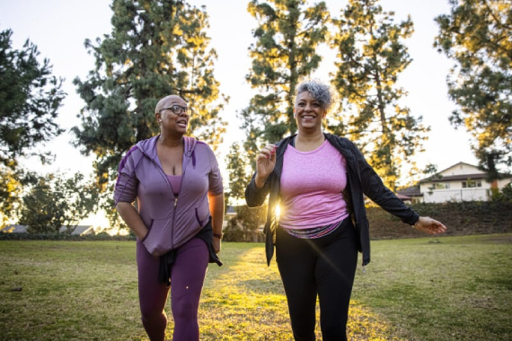 Two women doing a walking challenge in a park.