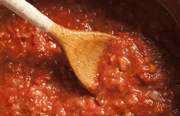 Wooden spoon in chunky tomato sauce