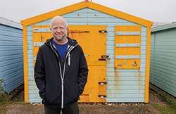 Gary Rolfe standing outside beach hut