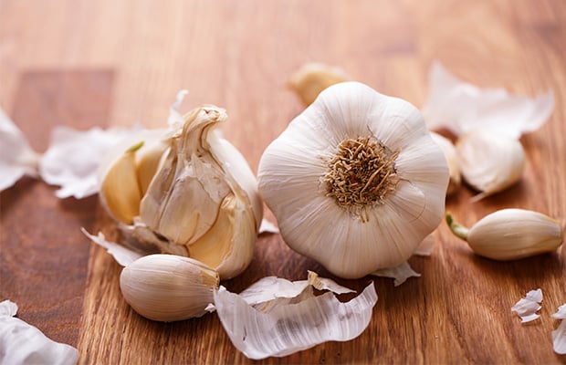 Garlic bulbs and cloves scattered on a table.