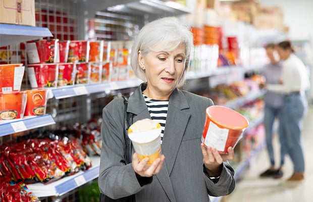 A woman comparing food labels in a supermarket.