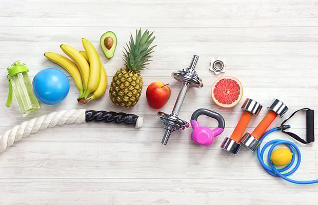 Weights, resistance bands, fruit and gym equipment from above.