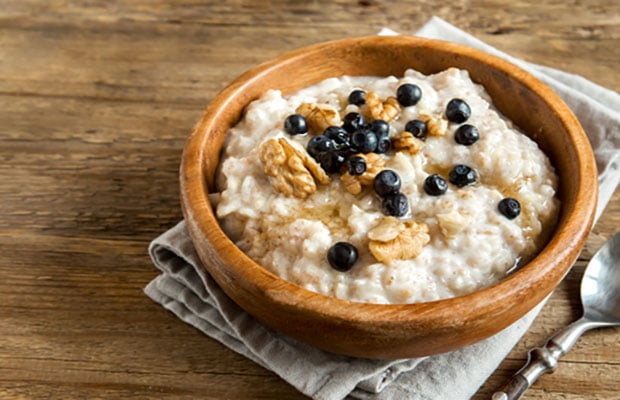 Bowl of oat porridge topped with walnuts