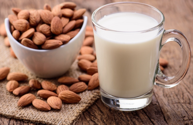 Bowl of almonds and a glass of almond milk
